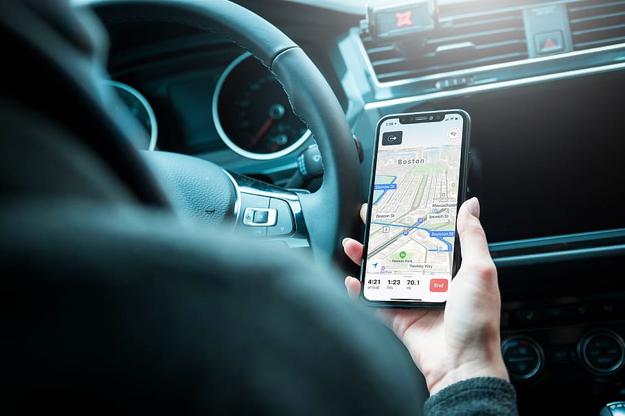 Driver holding a phone in hand with route planner app open